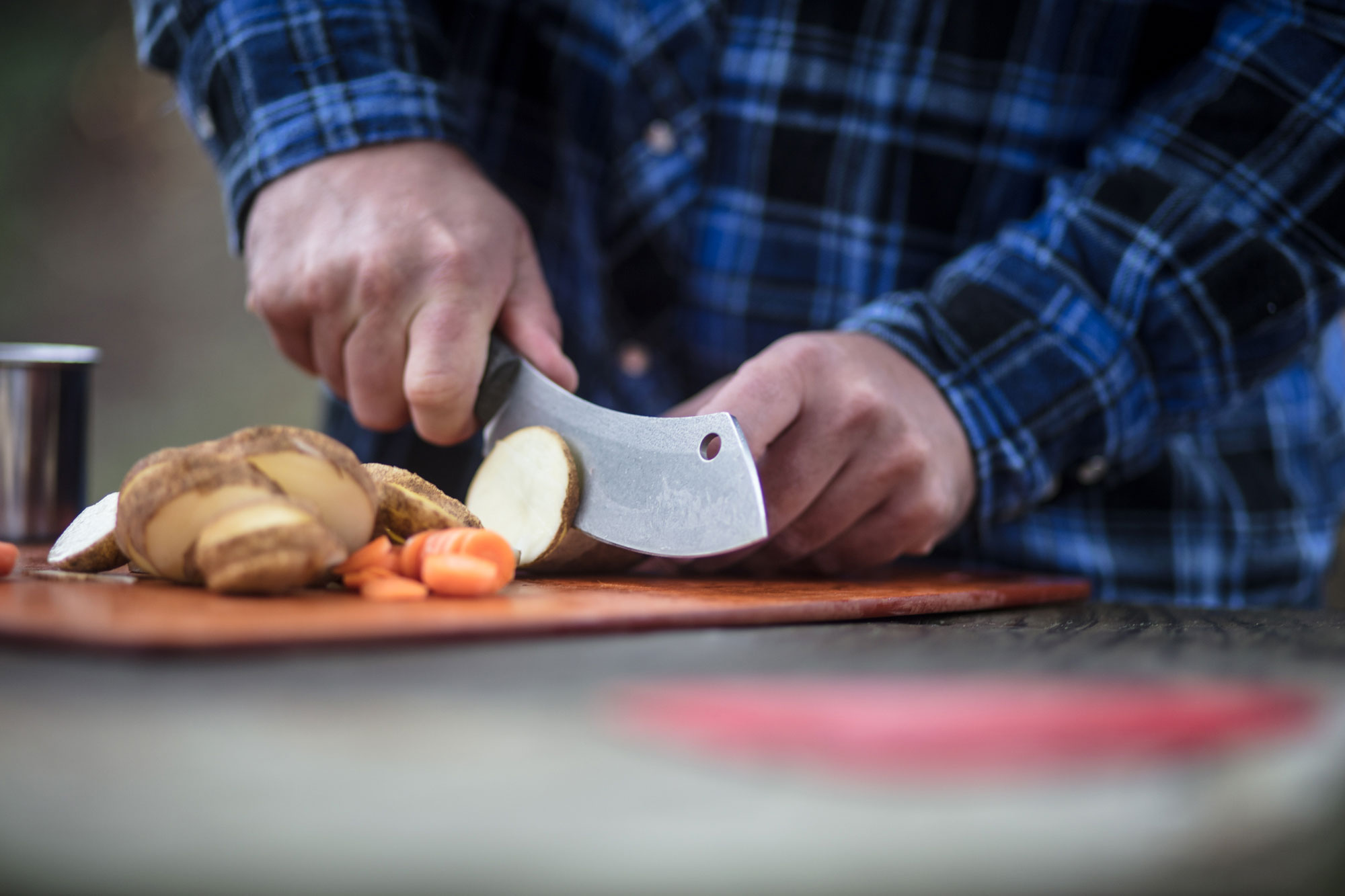 camping man uses knife to cut vegetables photography