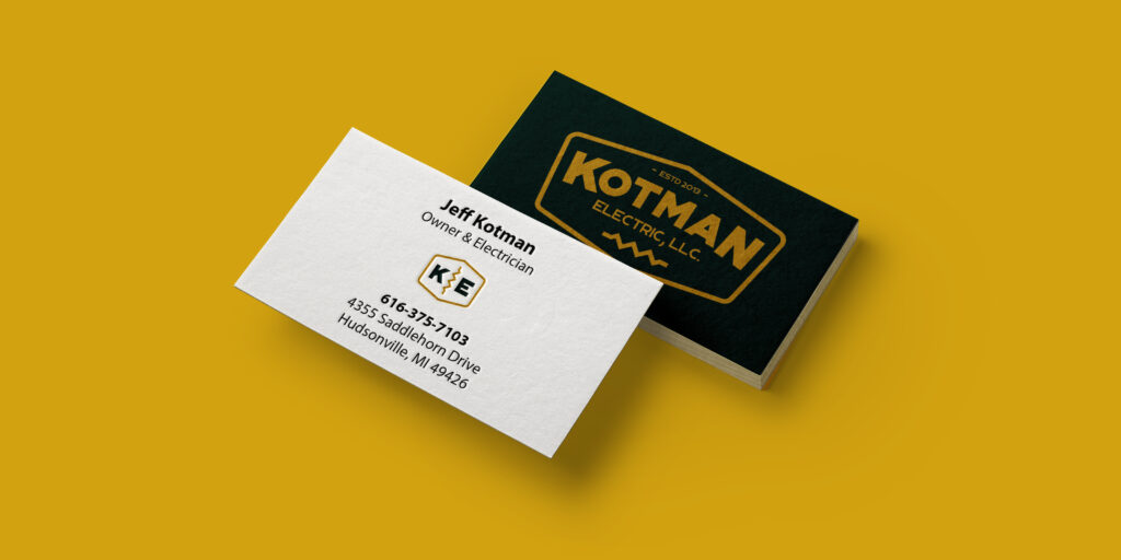 Kotman Electric business cards on a yellow background