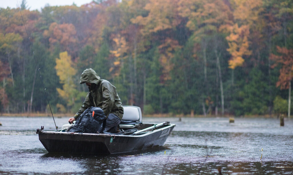 Fishing boat fisherman fishing on river in the fall