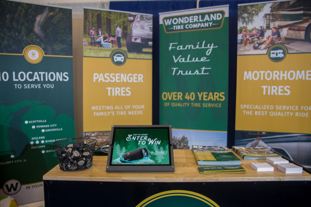 A sign explaining a giveaway at the Wonderland Tire booth at a trade show 